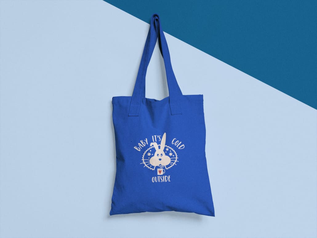 blue tote bag hanging from a nail on a two colors wall